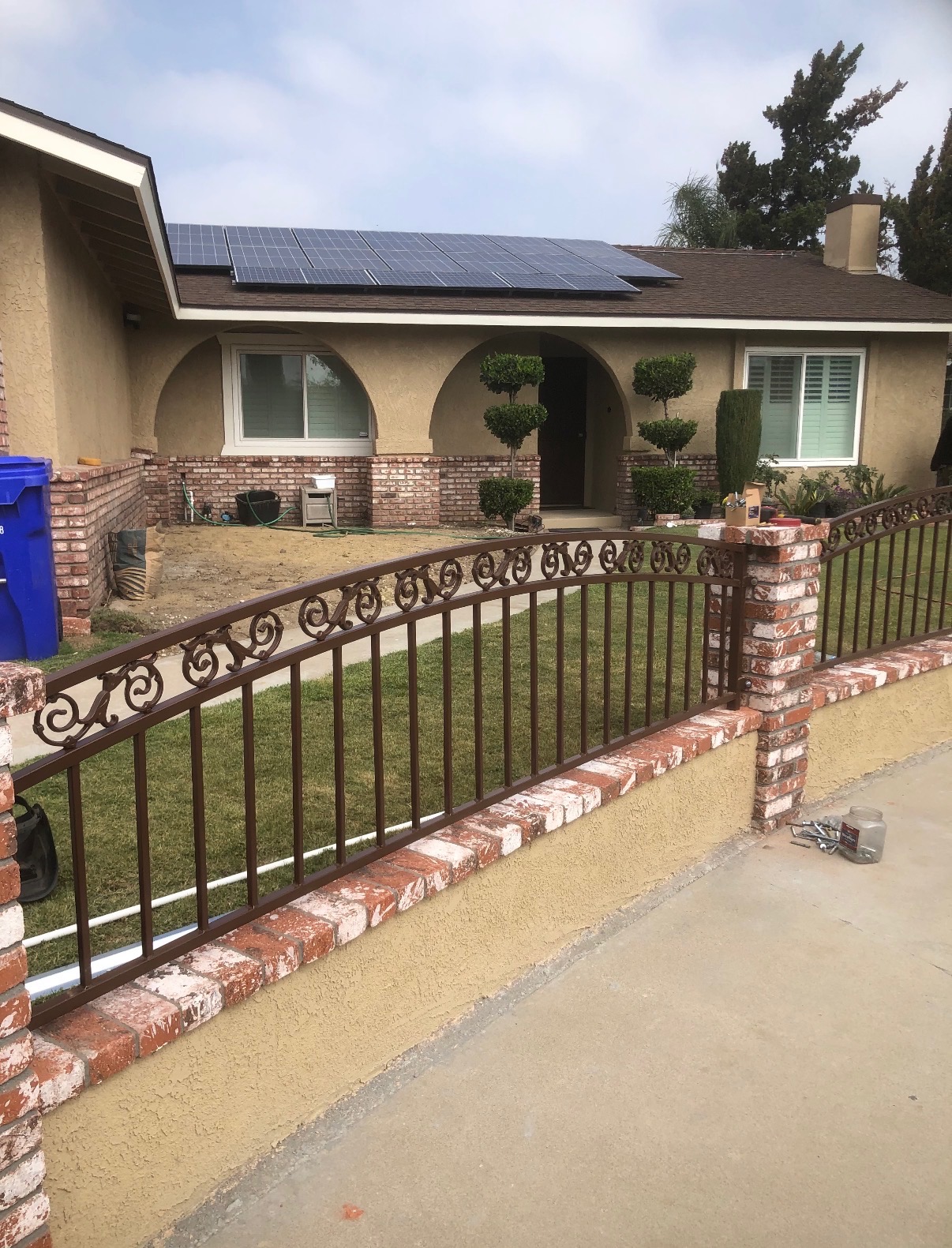 Wrought iron front yard fence with brick pillars
